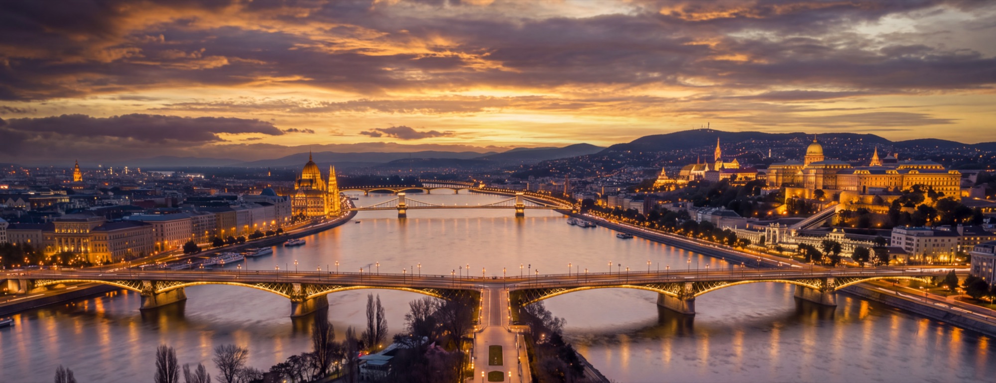 Margaret Bridge and Budapest at dusk over the Danube, with the Parliament and Buda Castle behind